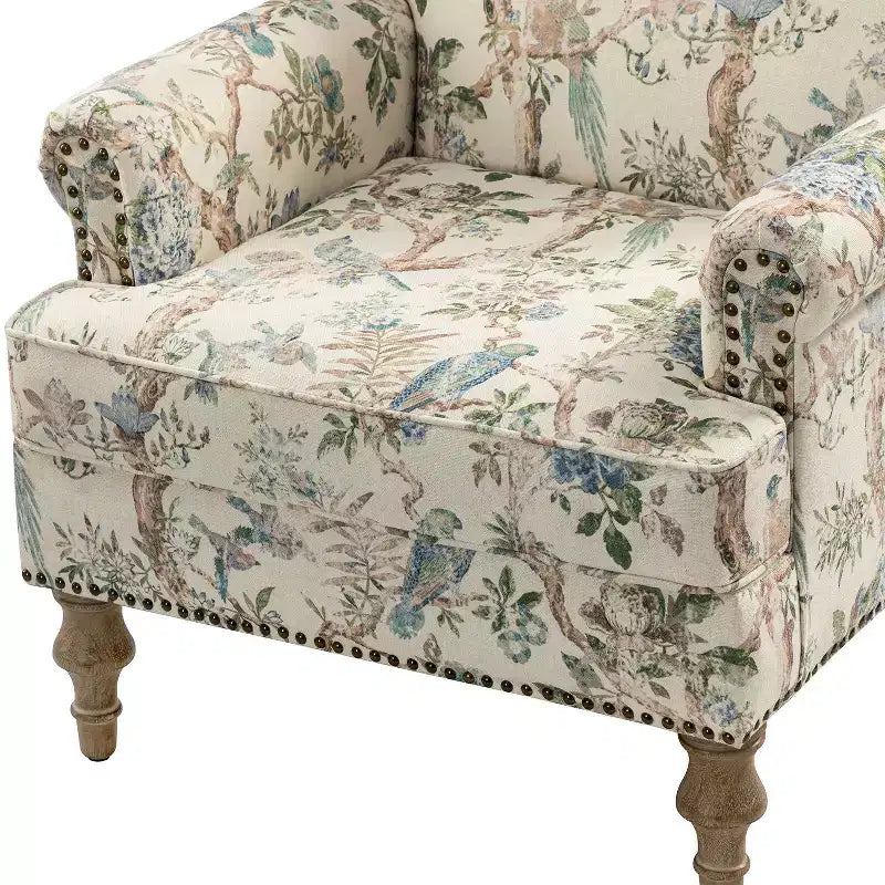 Fauteuil rembourré en bois avec motif floral, accoudoirs à panneaux et dossier en forme de bosse de chameau.