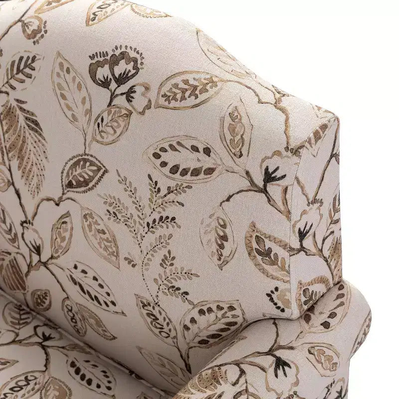 Fauteuil rembourré en bois avec motif floral, accoudoirs à panneaux et dossier en forme de bosse de chameau.